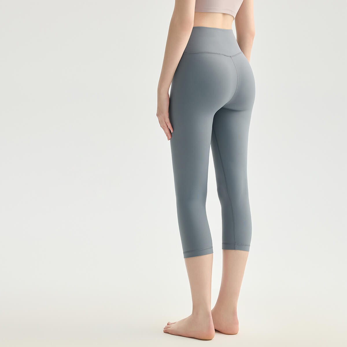 Back view of slate gray 3/4 length workout leggings made from buttery soft, squat-proof fabric.