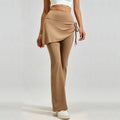 Woman wearing high-waisted 2-in-1 skirted flare leggings in tan color, side-tie ruched detail yoga pants.