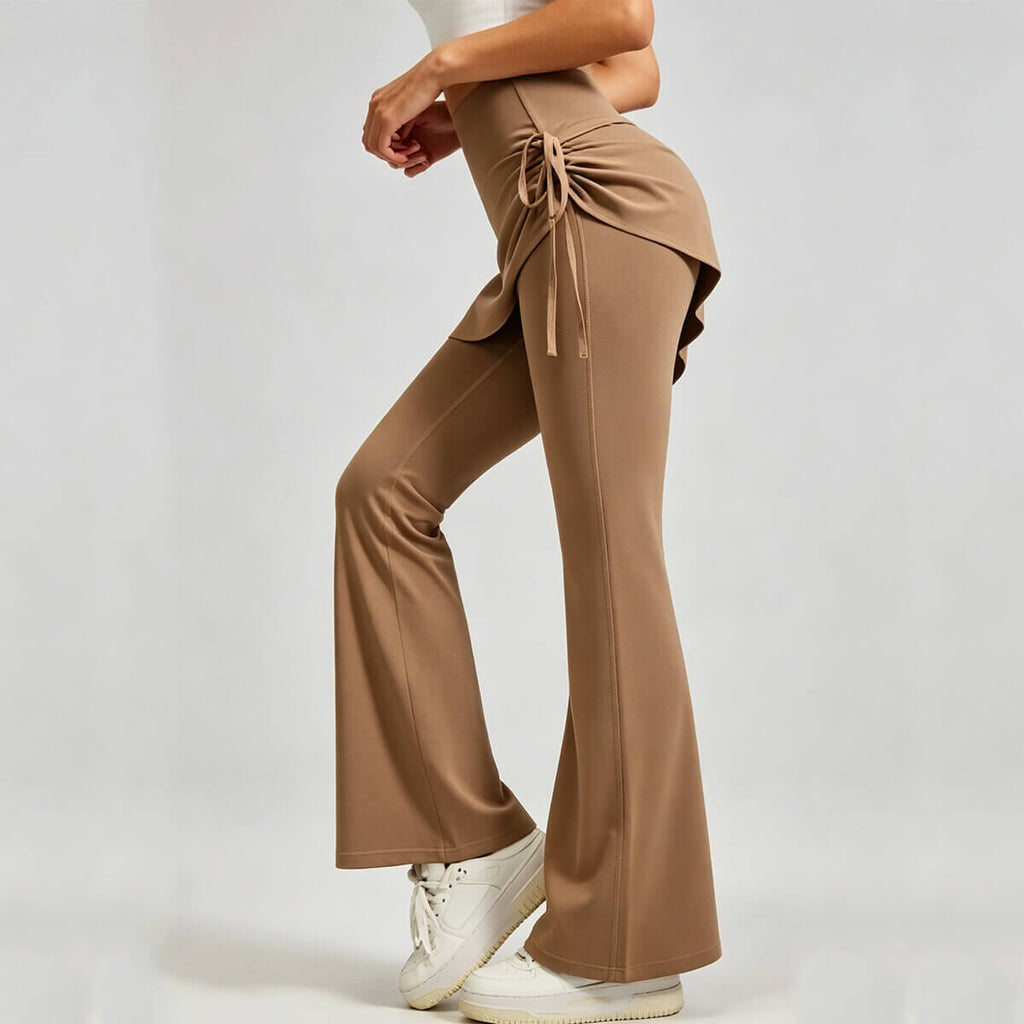 Side profile of tan 2-in-1 skirted flare leggings, highlighting the adjustable ruched side-tie and slimming flared leg silhouette.