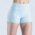 A woman wearing light sky blue athleisure fitness shorts made from high-stretch performance fabric.