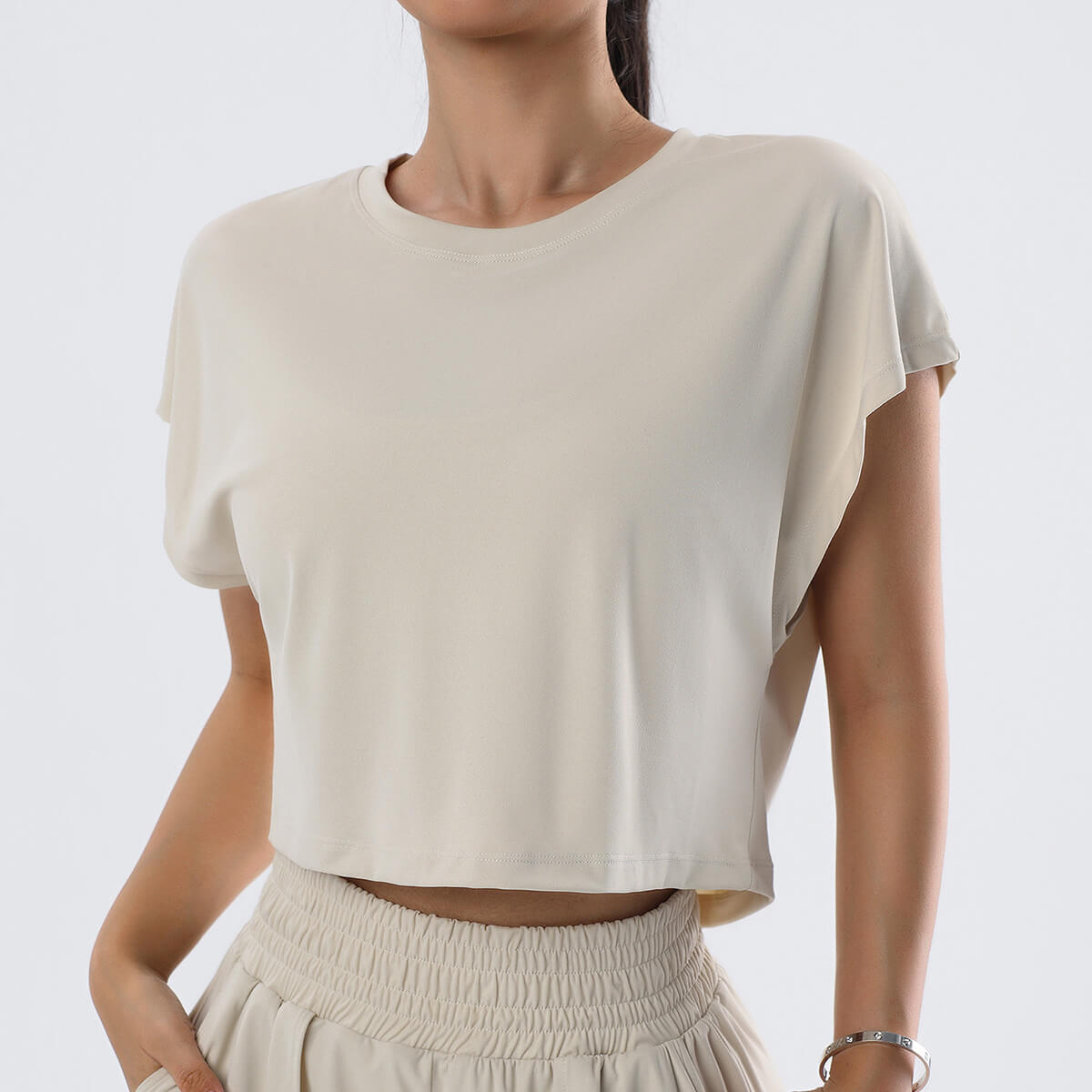 Front view of a sand-colored oatmeal cropped tee for effortless athleisure styling.