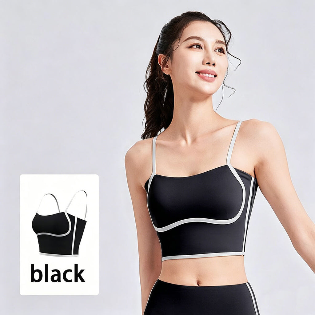 A smiling woman wearing a classic black yoga camisole top with white contrast piping, suitable for the gym or casual everyday wear