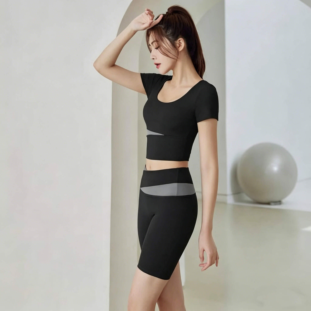 Side profile of a woman wearing a black crossover waistband biker shorts set with grey accents, perfect for gym, yoga, or casual wear