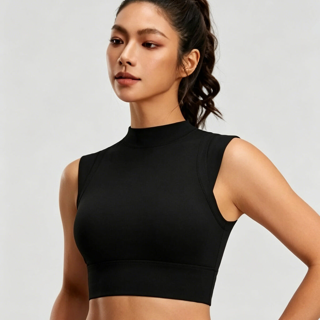 Angled front view of a black high-neck sleeveless crop top showing the snug, supportive fit and high-coverage athletic neckline