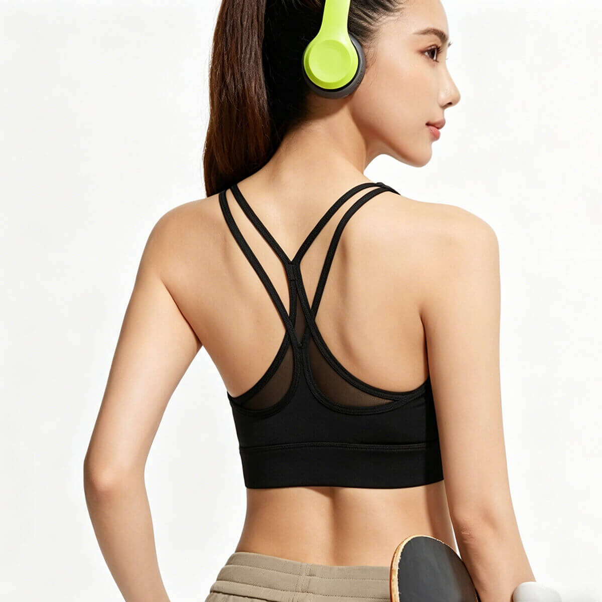 Side-back view of a classic black strappy back sports bra with mesh detailing, perfect for gym training and running