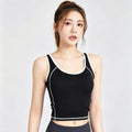 Women's black workout crop top with white contrast piping trim and visible flatlock seams for a stylish gym look