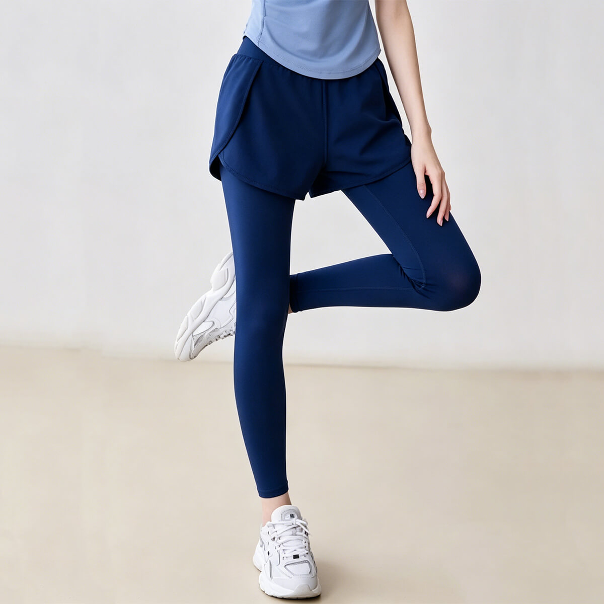 Side view of blue double-layer workout leggings in a motion pose, showcasing flexibility and breathable fabric