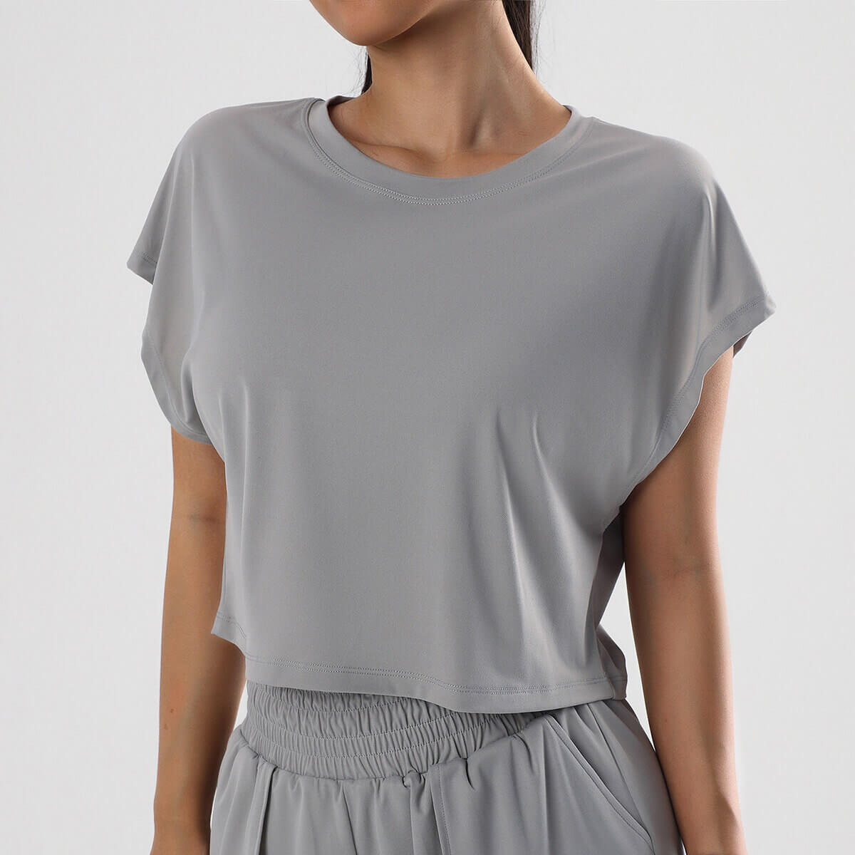 Slate grey short-sleeve cropped athletic shirt featuring a comfortable crew neck.
