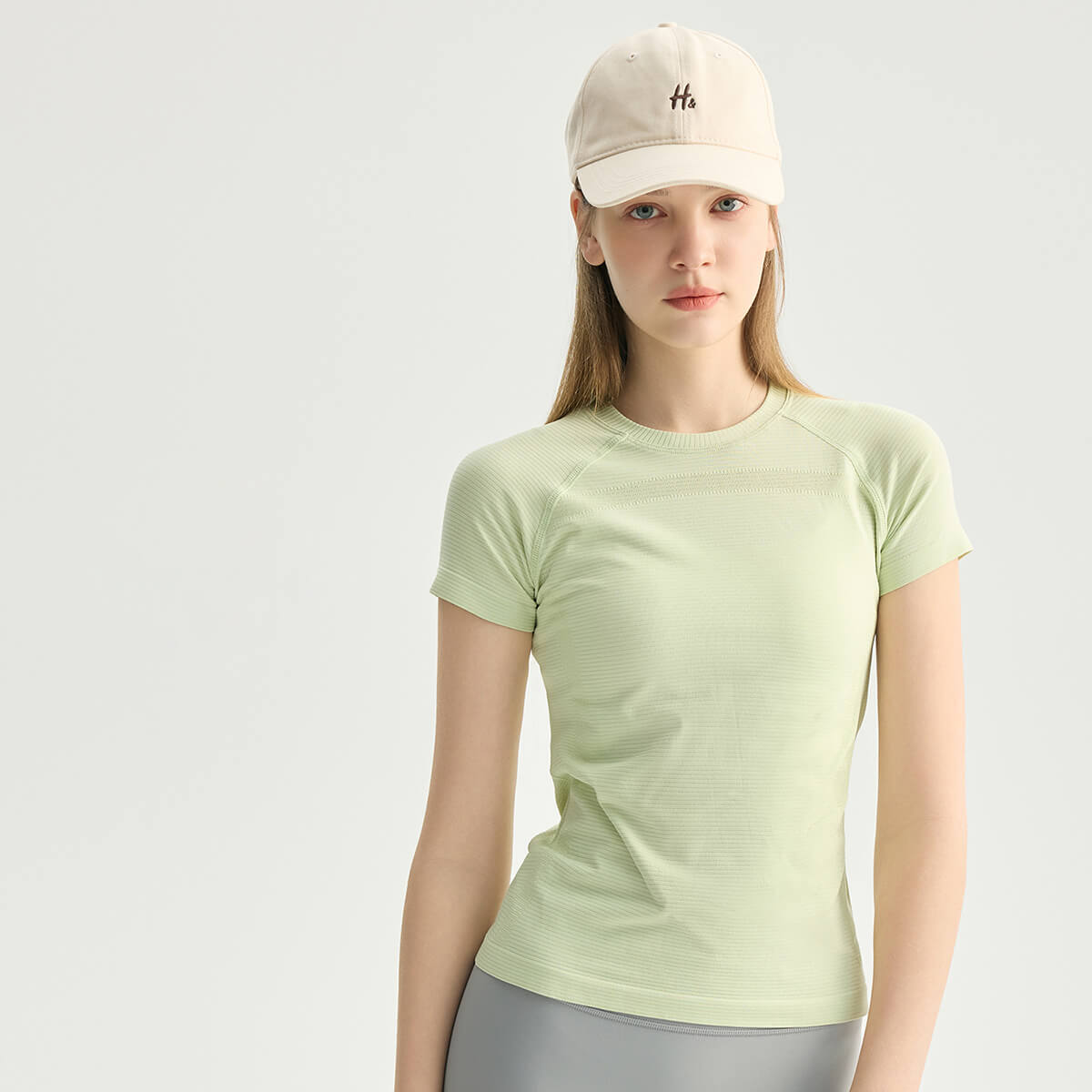 Sage green breathable performance workout top for women, featuring a flattering contoured fit.