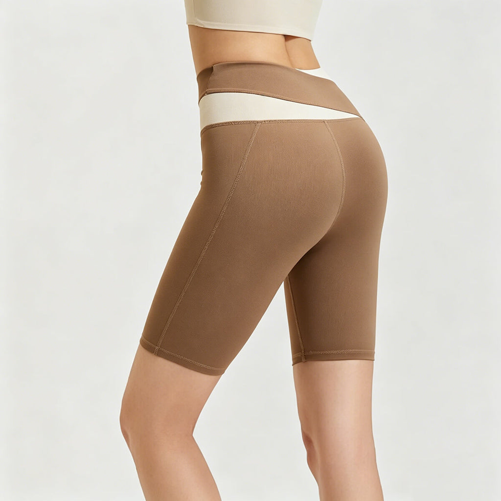 Rear side view of women's brown high-waisted biker shorts featuring a unique cream crossover waistband for tummy control.