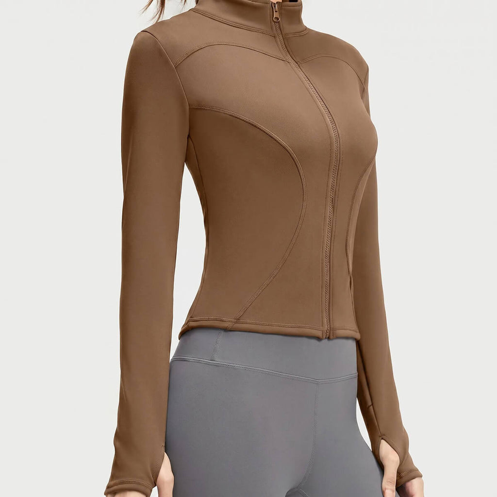 A coffee brown women's athletic zip-up jacket showcasing the functional thumbholes and curved hem for a stylish, sporty look.