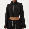Women's black two-piece streetwear set with a cropped full-zip jacket and high-waisted cargo pants.