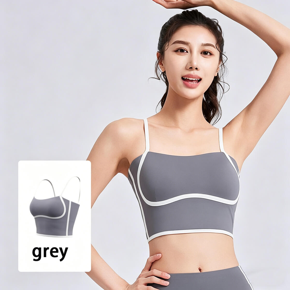 A woman modeling a grey activewear crop top with white contrast piping, designed for pilates, studio training, and athleisure