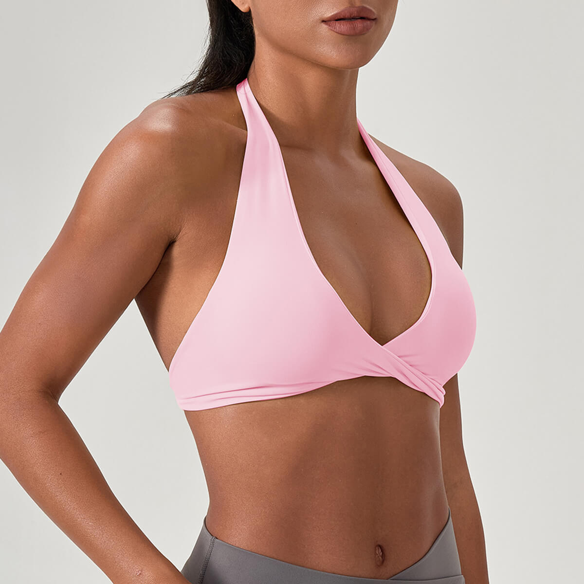 Light pink halter style sports bra with a cross-front design, ideal for hot yoga and fitness enthusiasts.