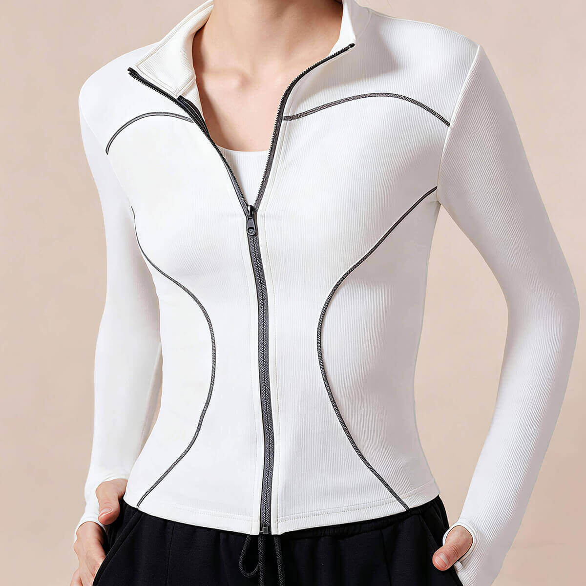 Close-up of a white yoga jacket with hourglass-contouring grey seams and a full zipper closure for a sleek athletic look.