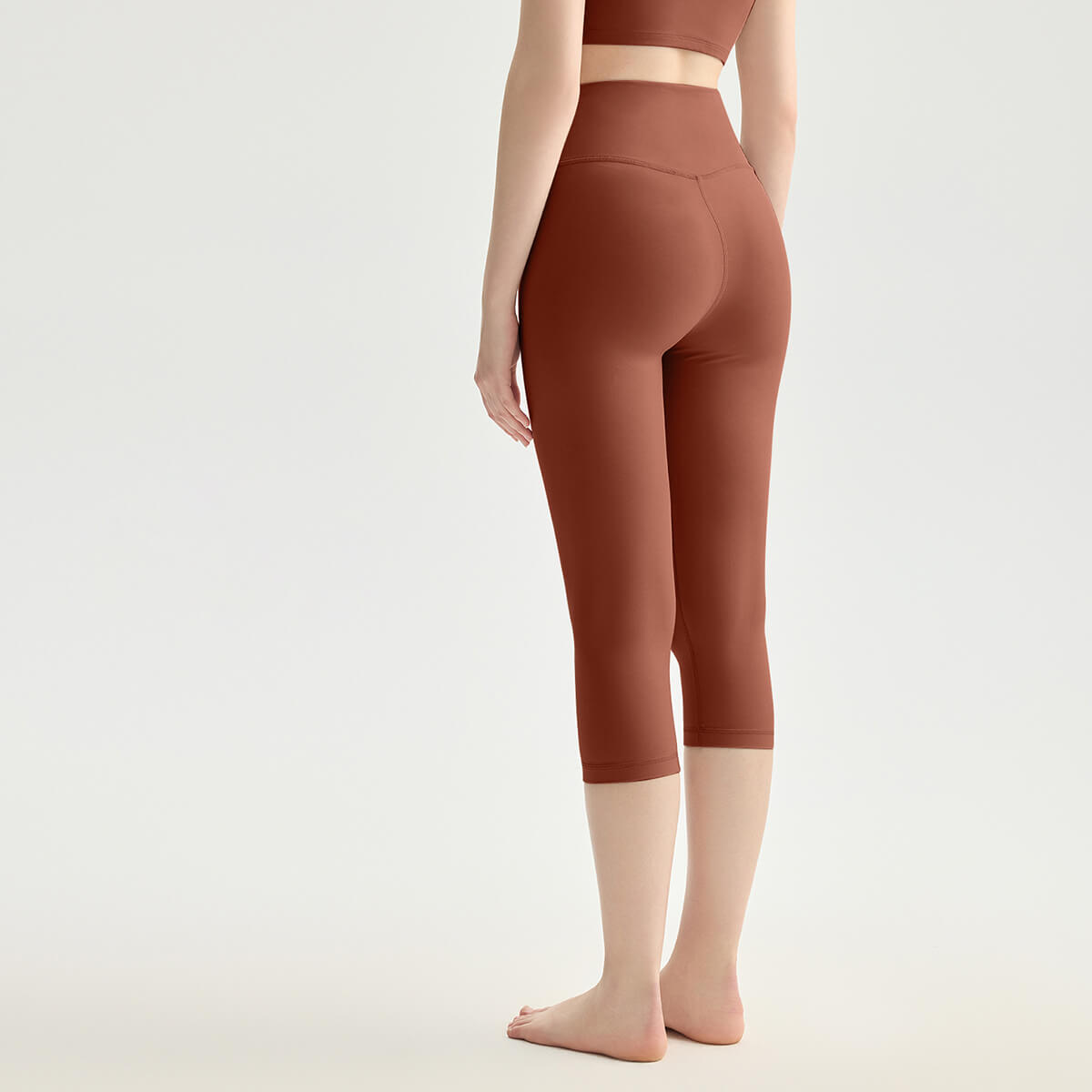 Rear view of espresso brown high-rise capri leggings showcasing the flattering glute seams.
