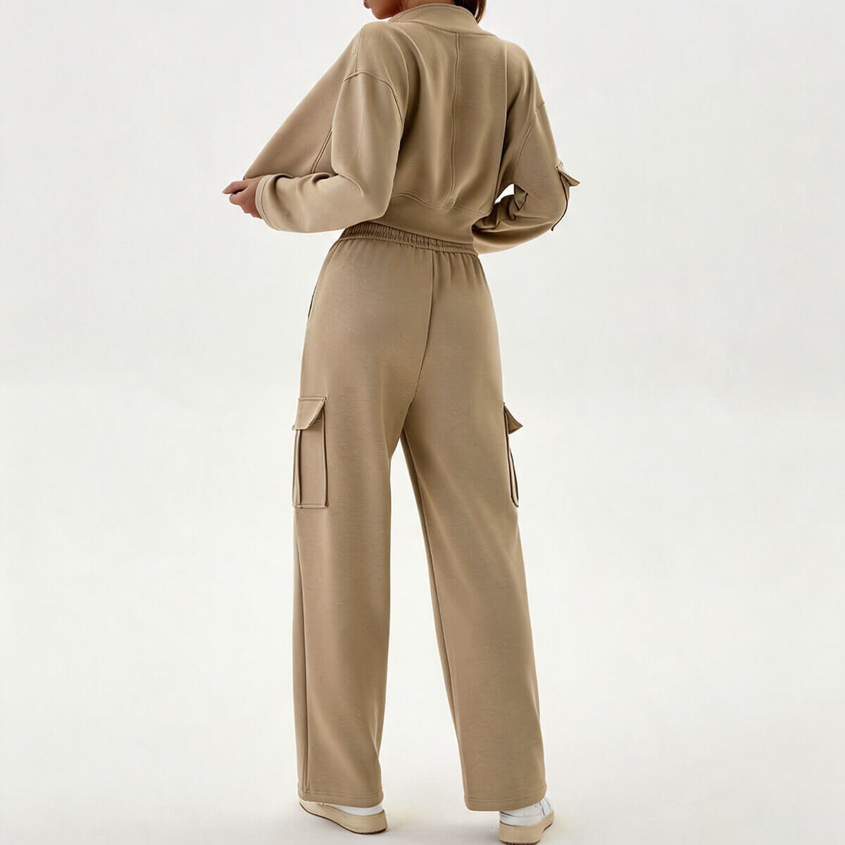 Side and back view of a khaki cargo tracksuit showing the baggy pocket details on the joggers and the cropped fit of the top.