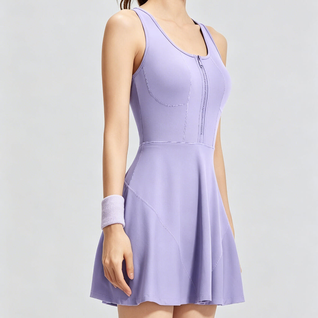 A woman wearing a lavender purple sleeveless golf dress with a zip-up collar and pleated skirt