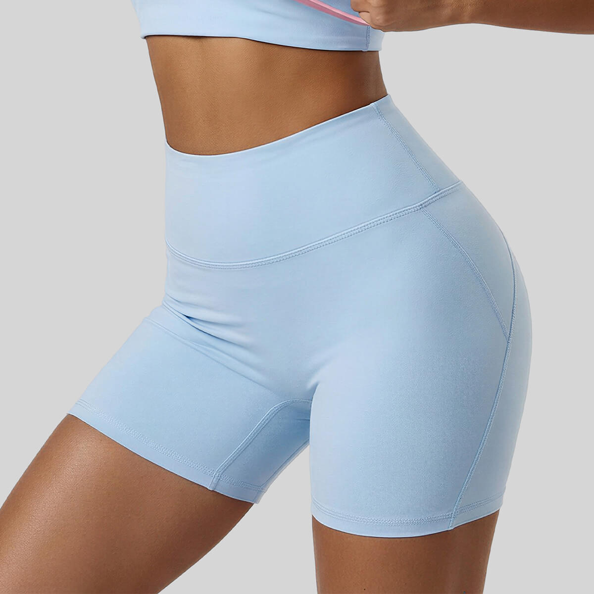 Side view of light blue high-waisted yoga shorts showing the seamless front design and supportive athletic fabric.