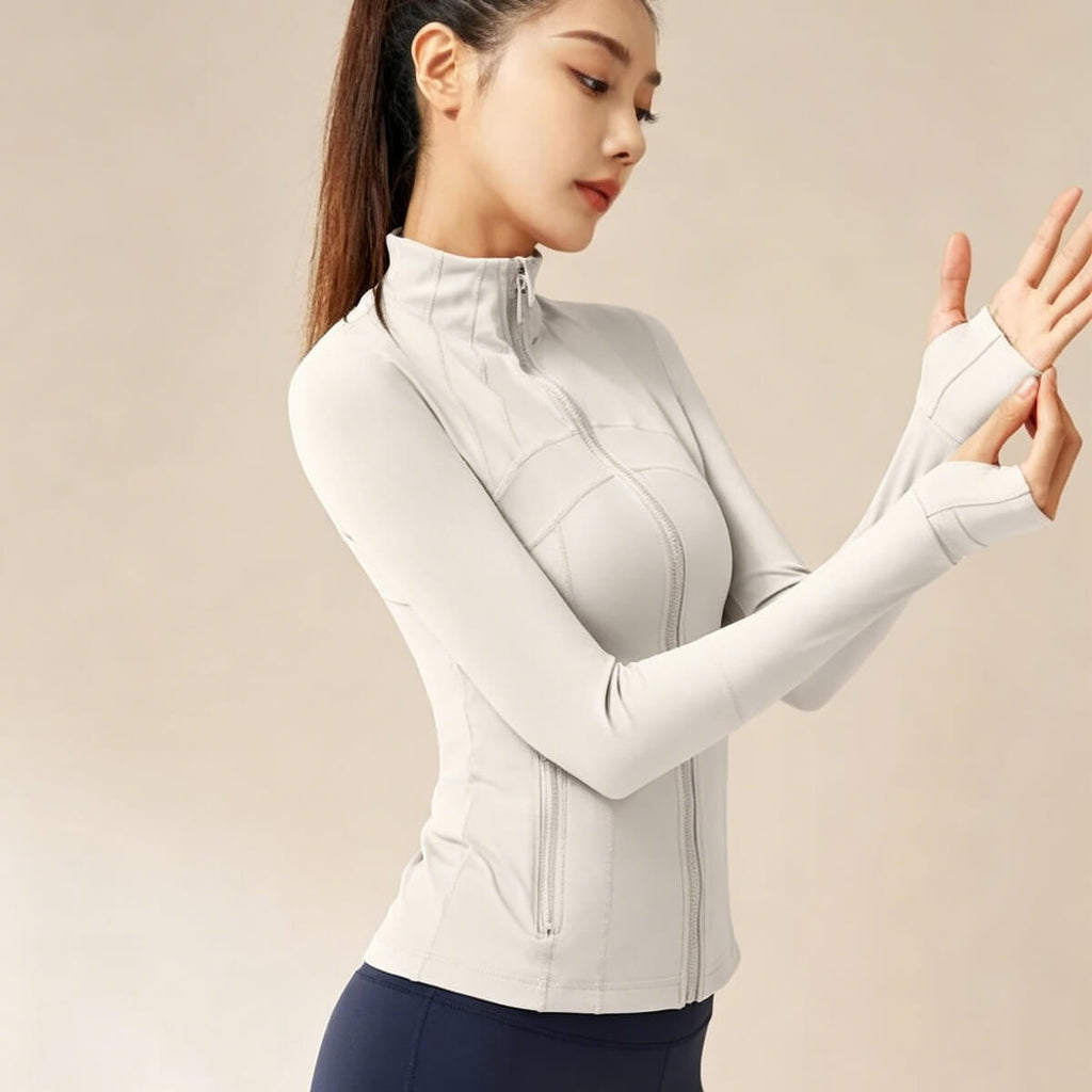 Light gray running track jacket for women made with moisture-wicking stretch fabric and ribbed cuff details