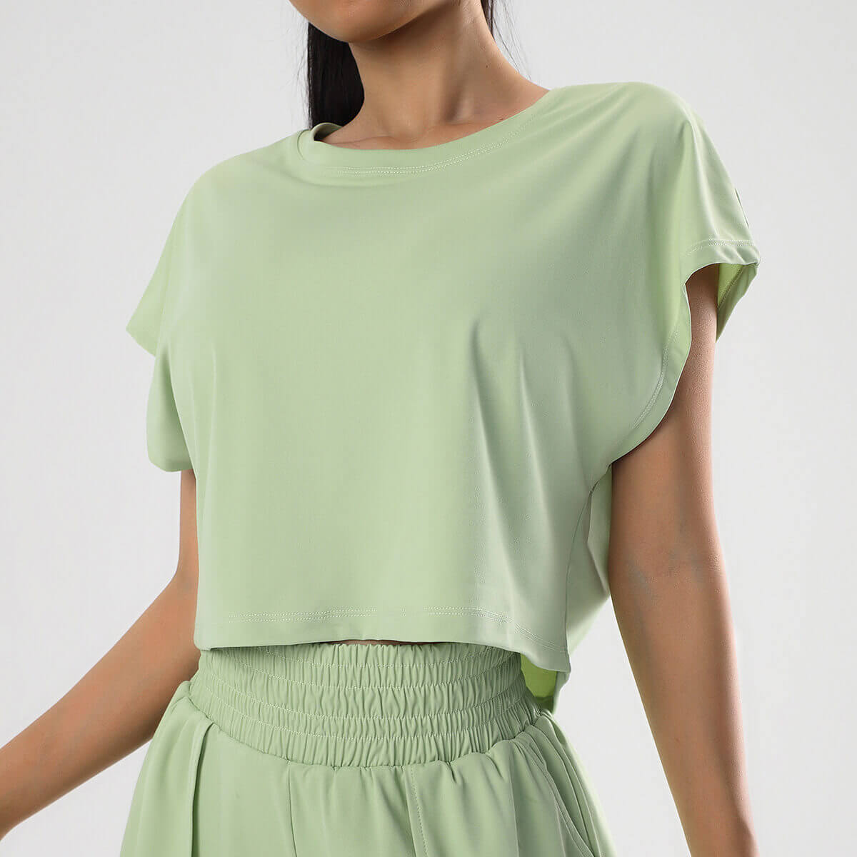 Women's sage green oversized crop top with dolman sleeves for yoga and gym sessions.