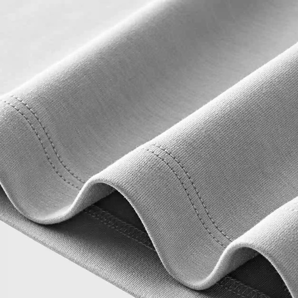 Close-up of bottom hem double stitching and soft fabric on men's t-shirt with custom logo, supplied by garment manufacturer.