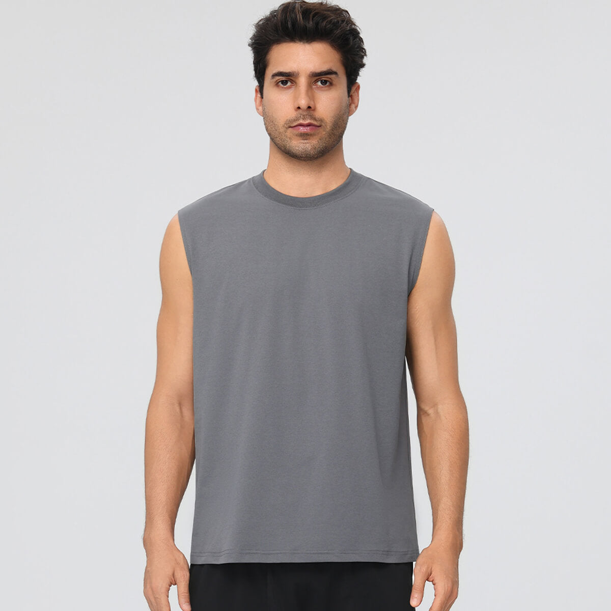 A man wearing a solid grey sleeveless gym shirt, ideal for bodybuilding and exercise.