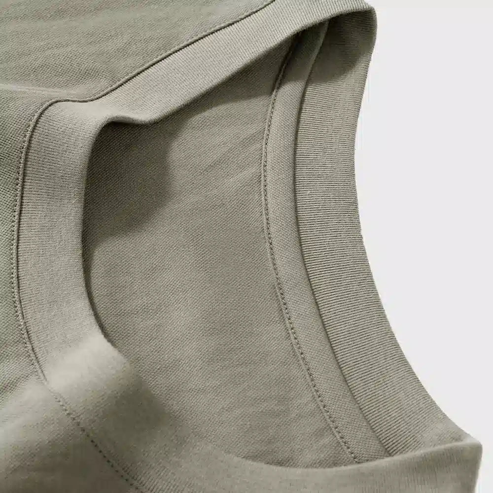 Close-up view of ribbed crew neckline on men's green linen cotton t-shirt with custom logo, OEM apparel manufacturer.