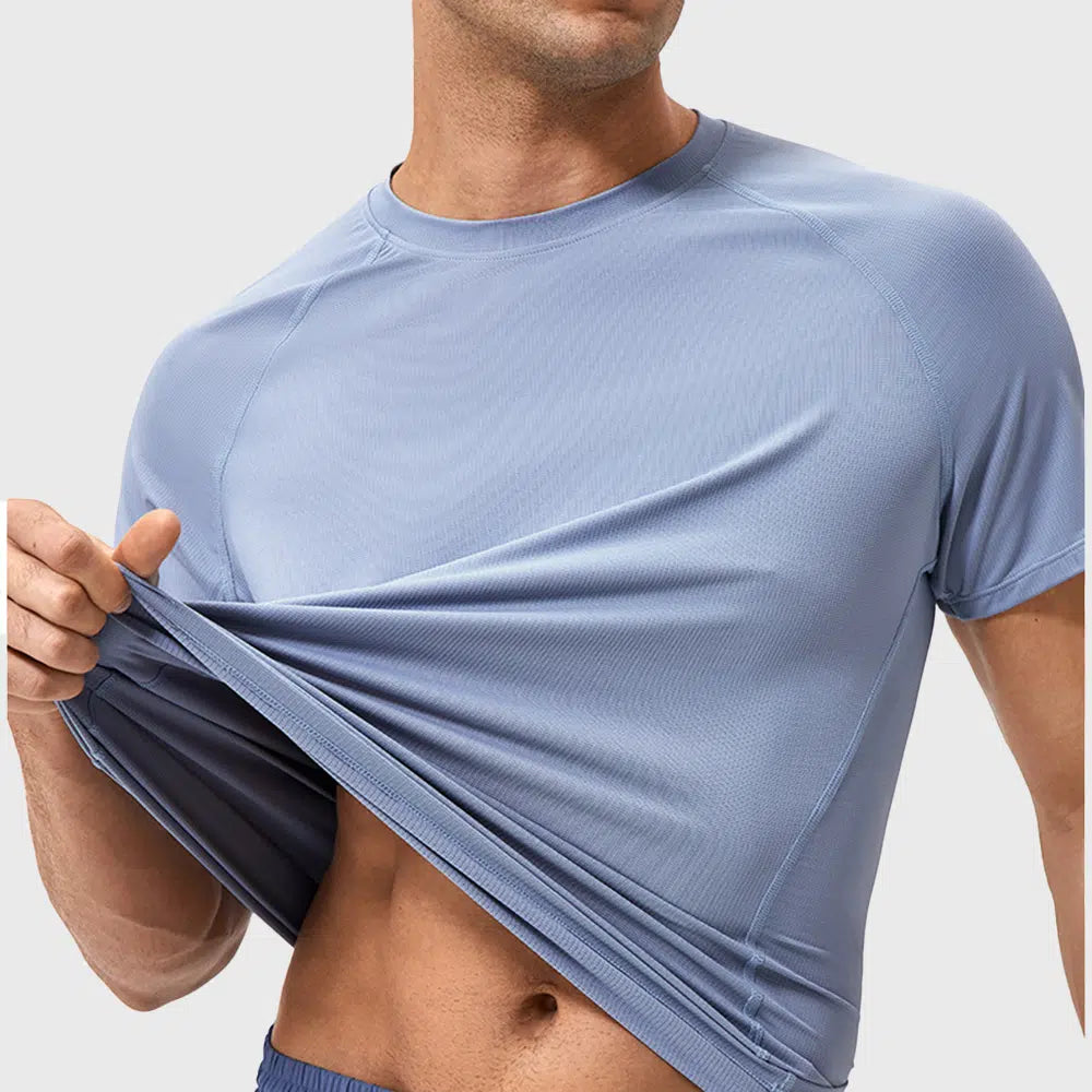 Close-up view demonstrating lightweight breathable fabric on men's blue running shirt with custom logo, OEM gym wear manufacturer.