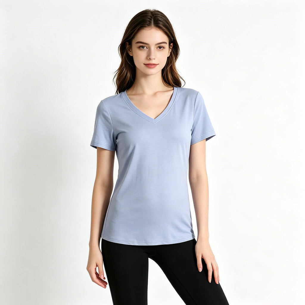 A young female model wearing a light blue 80S premium cotton V-neck T-shirt, demonstrating its flattering and relaxed fit.