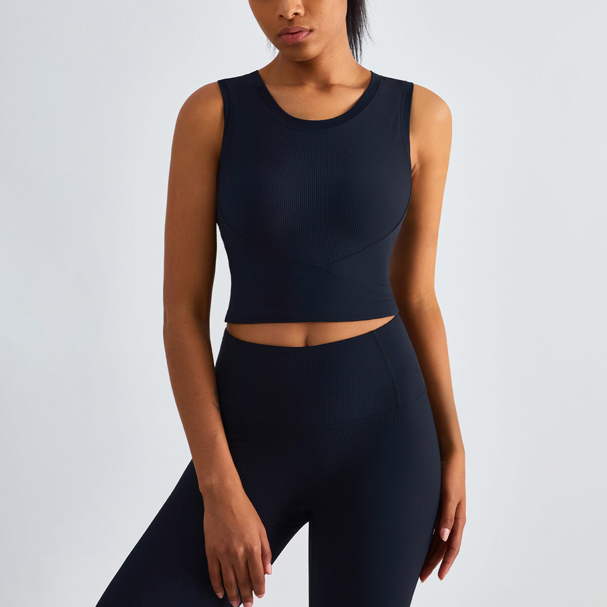 Model wearing a navy blue high-neck ribbed athletic crop top, perfect for gym training and yoga sessions.