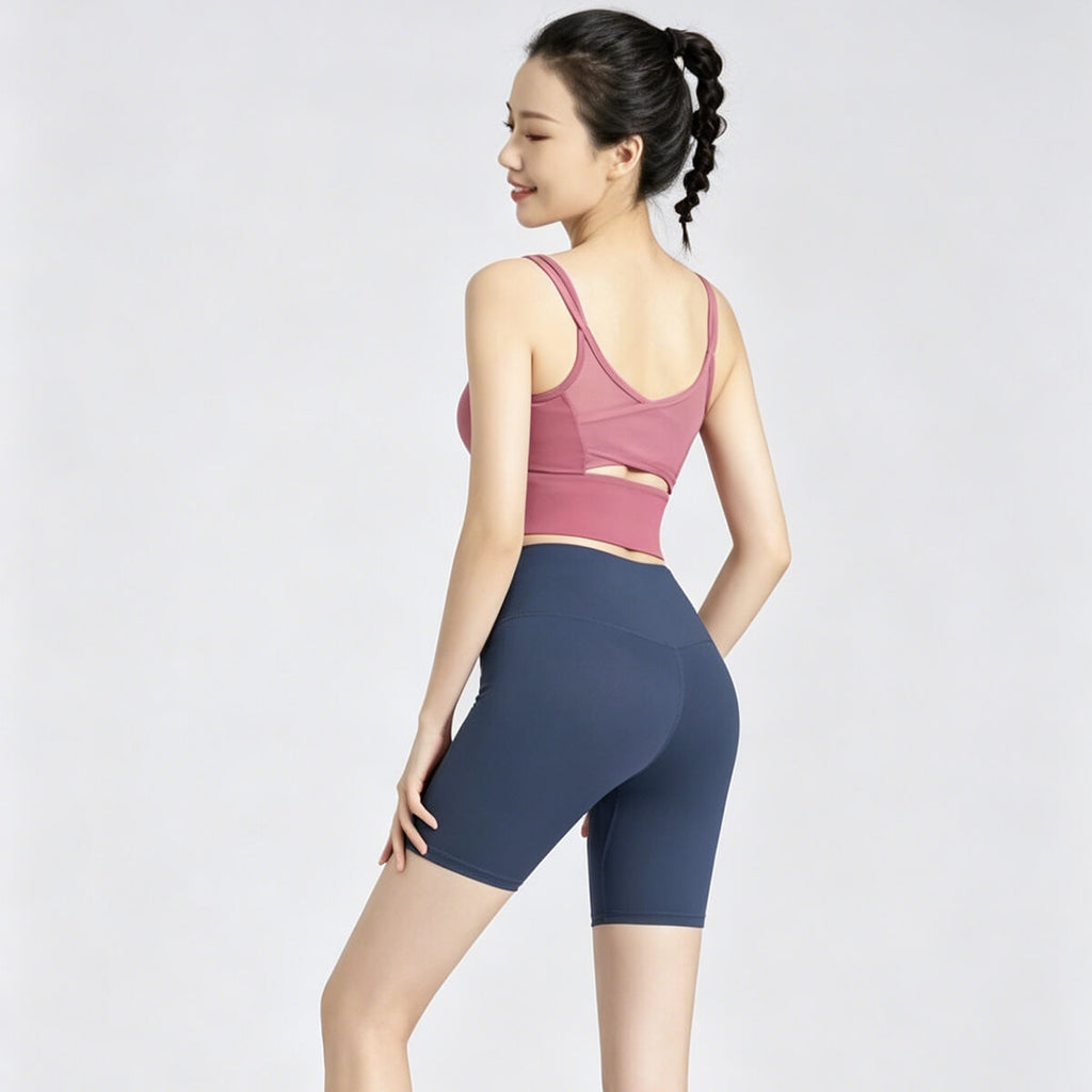 Model from behind wearing navy blue 5-inch yoga biker shorts, showing the flattering V-shape back seam and compression fit.