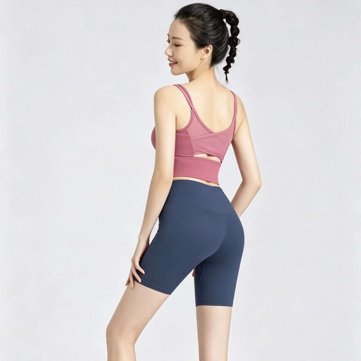Model from behind wearing navy blue 5-inch yoga biker shorts, showing the flattering V-shape back seam and compression fit.