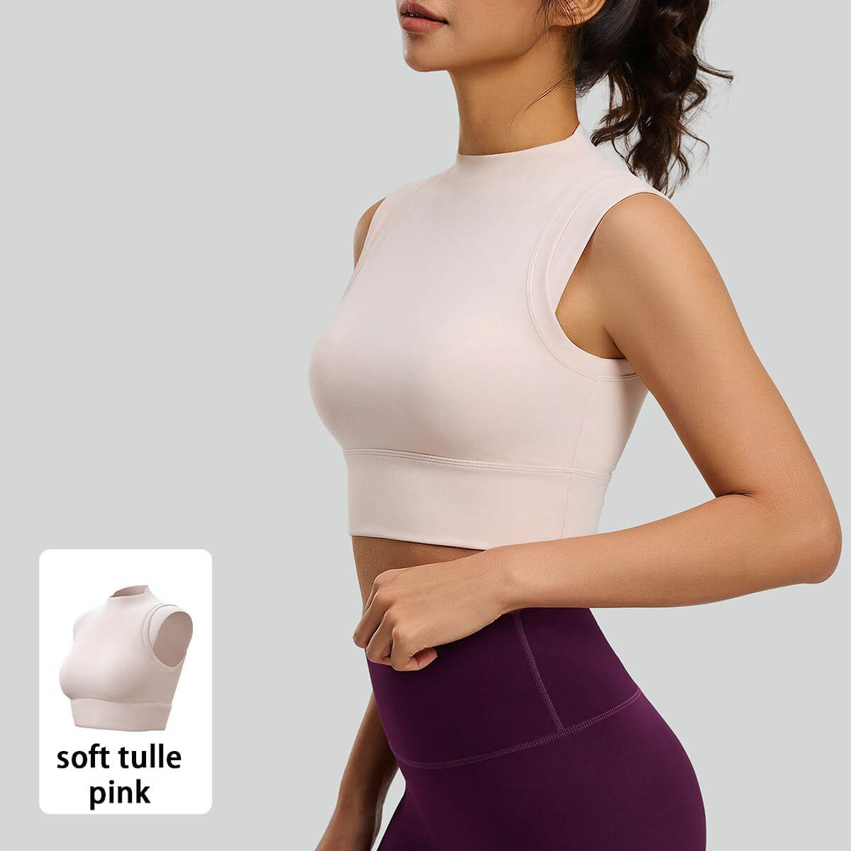 Side profile of a soft pastel pink mock neck activewear crop top paired with high-waisted leggings for pilates and studio fitness