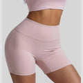 Front and side view of pink athletic biker shorts showing the high-rise tummy control waistband and slimming fit