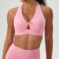 Pink v-neck sports bra with a stylish front twist and keyhole cutout detail.