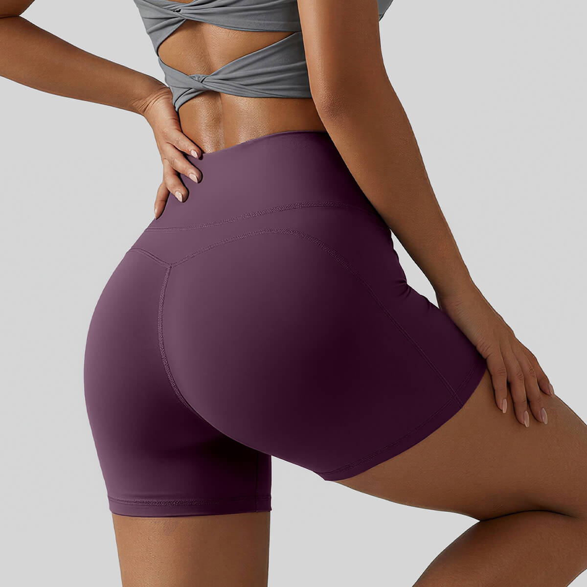 Rear view of plum purple high-waisted gym shorts featuring flattering booty-contouring lines and compression fabric.
