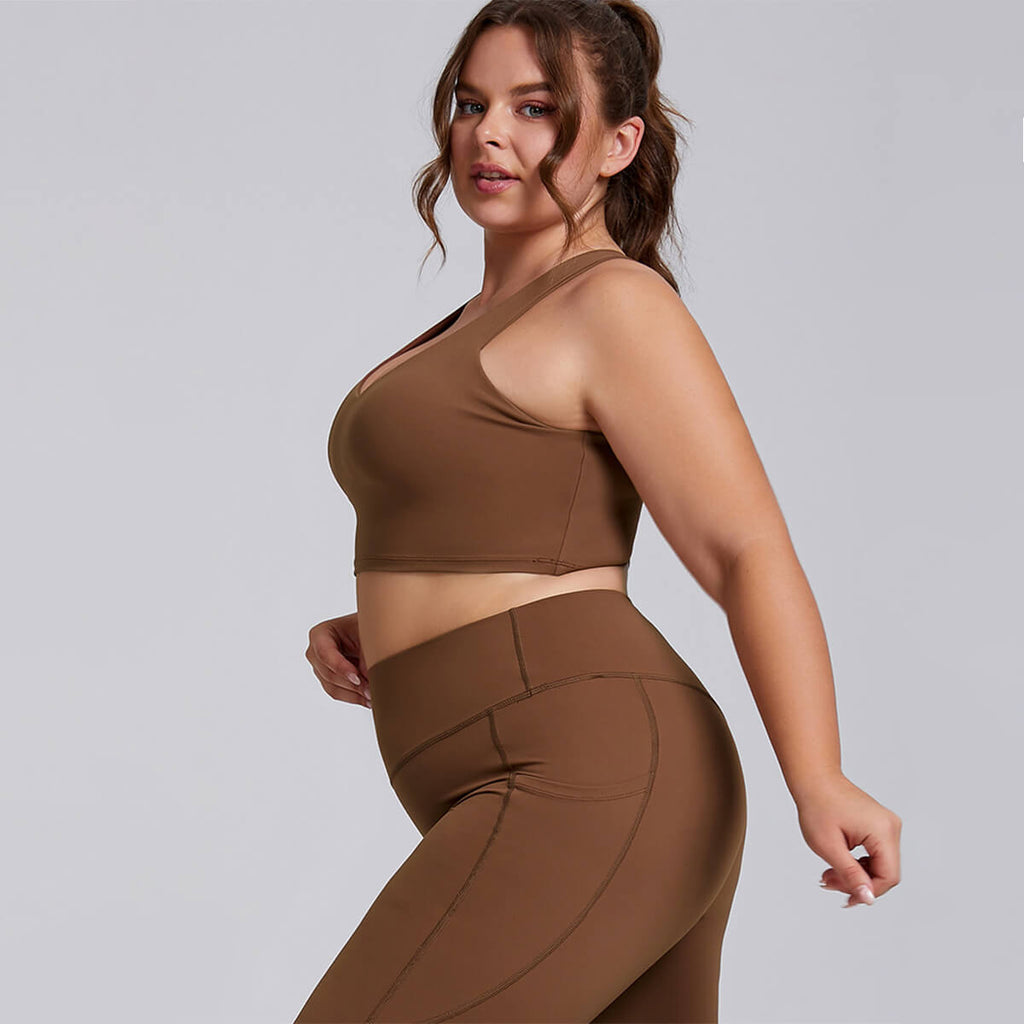 Side profile of a curvy woman in a brown sports bra and high-waisted leggings.