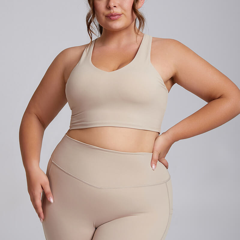 Plus size woman in a nude beige longline athletic sports bra.
