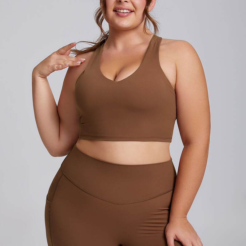 Plus size woman modeling a chocolate brown longline sports bra.