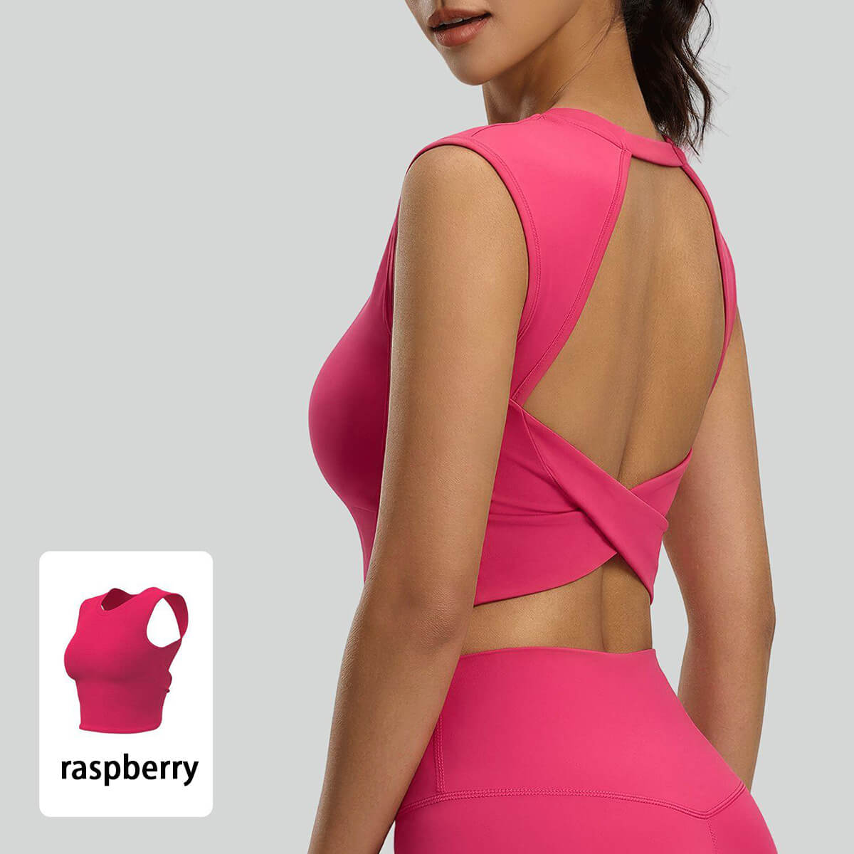 Close-up detail of the criss-cross open back and twisted hem on a raspberry pink sports top, high-quality fabric with a vintage sporty chic vibe