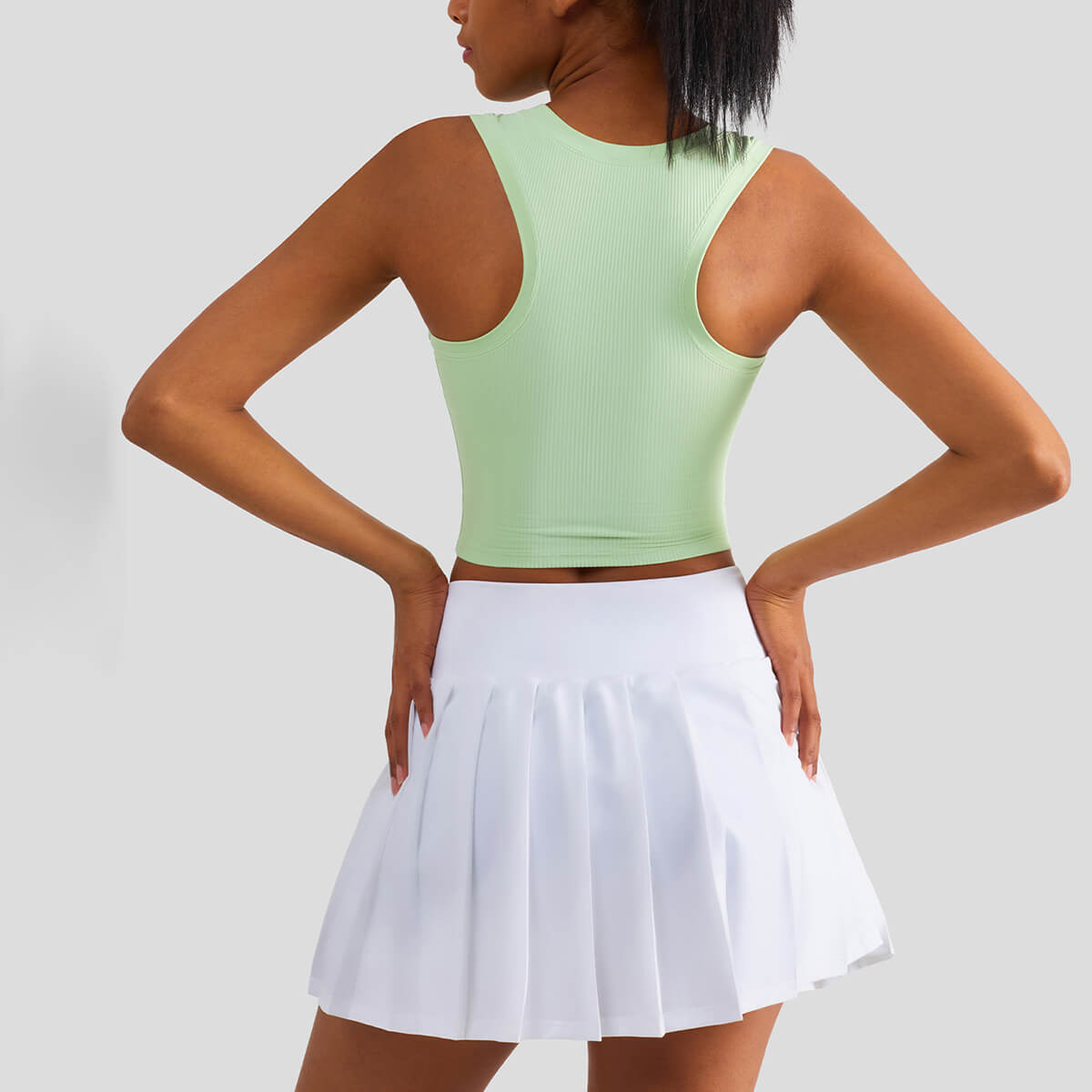 Back view of a sage green racerback ribbed crop tank top showing the stylish athletic cut and breathable fabric.