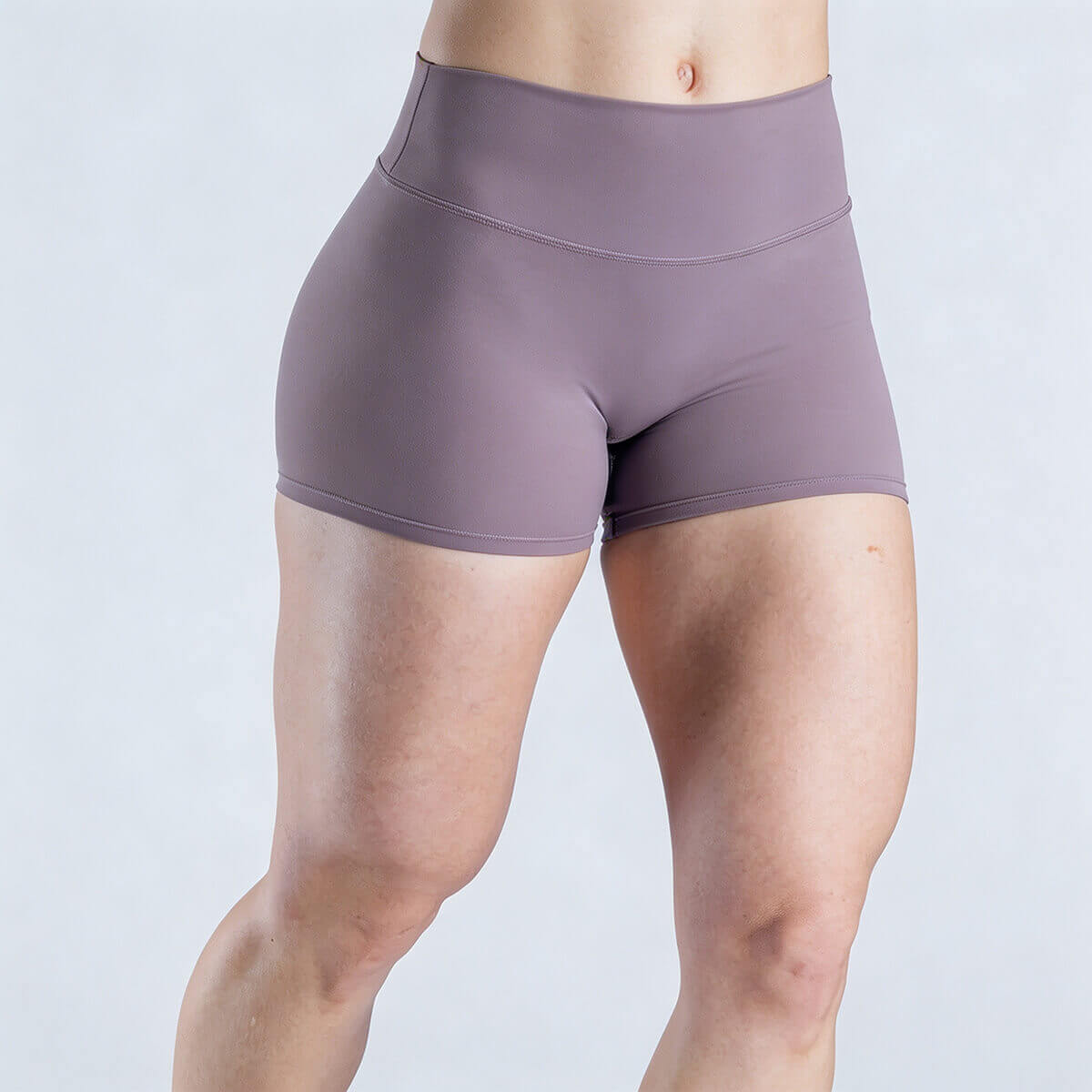 Side view of mauve scrunch-butt athletic shorts highlighting leg muscle contour and flexibility.