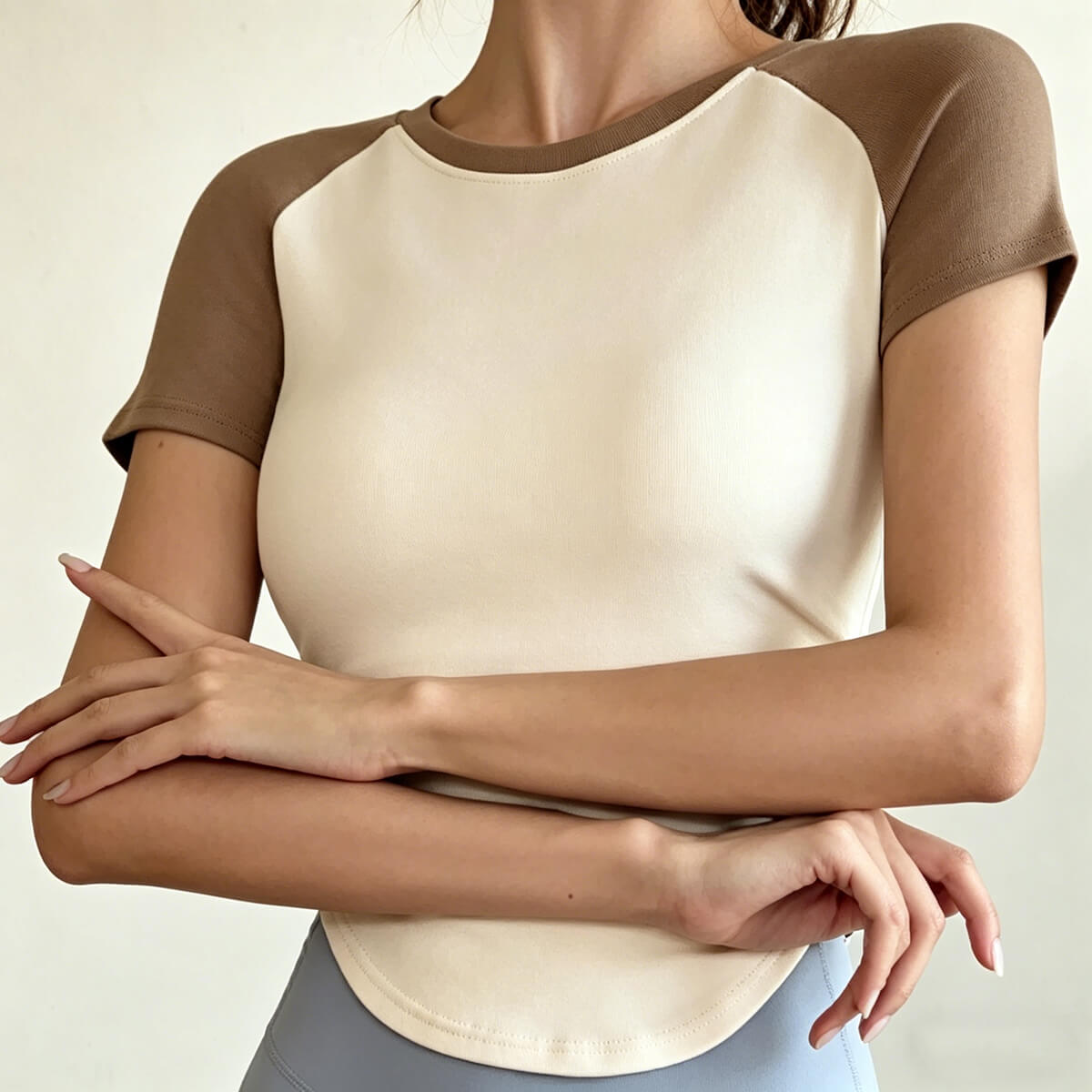Front view of a slim-fit colorblock athletic shirt with short raglan sleeves, designed for breathable comfort during yoga or gym sessions.