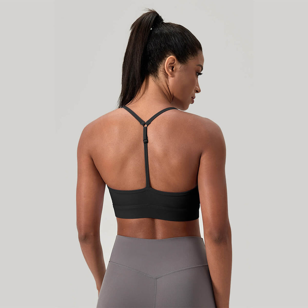 Back view of a black sports bra featuring a minimalist thin Y-back strap design to allow for a full range of motion during workouts.