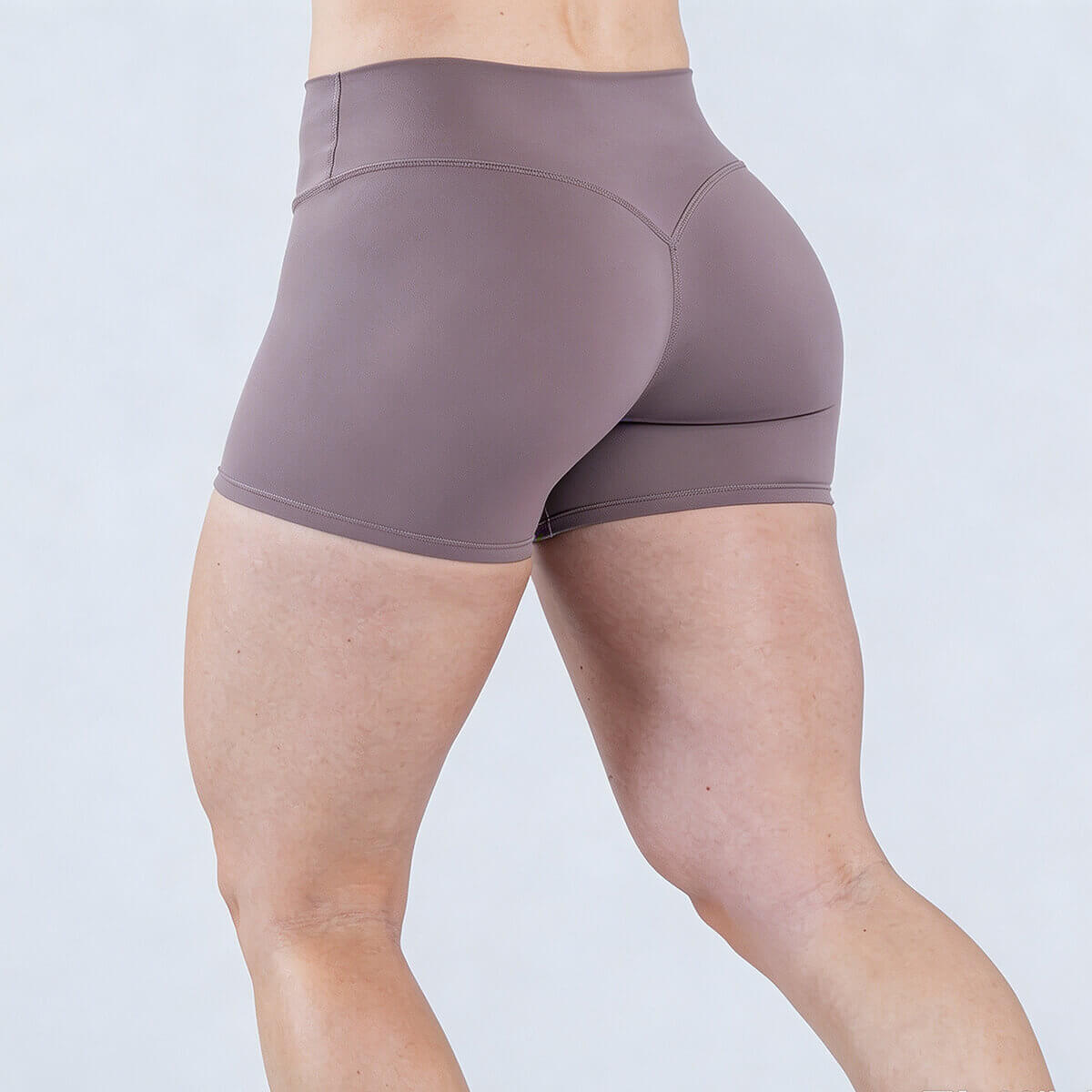 Rear view of mauve yoga shorts showcasing the glute-enhancing V-contour seam design.