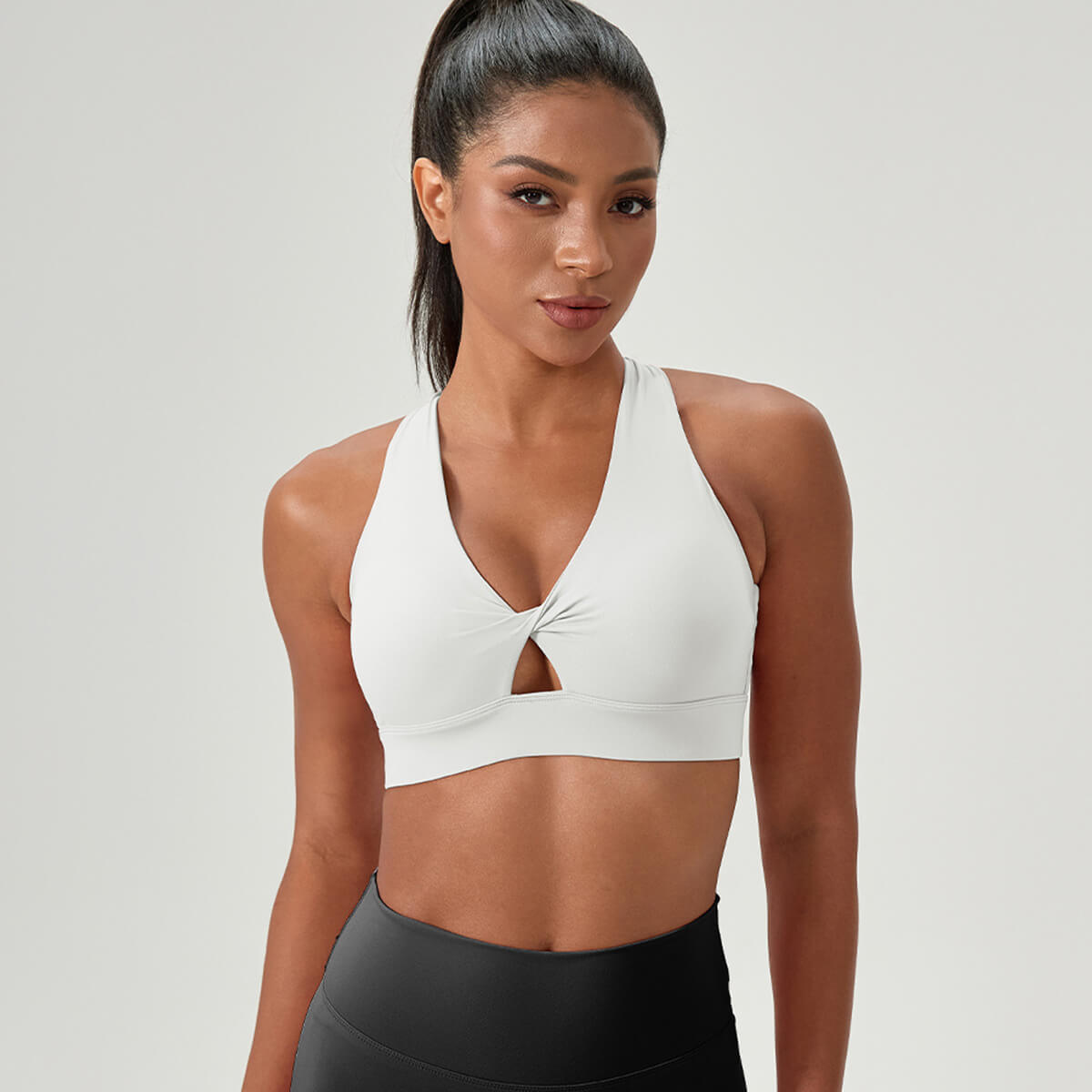 White v-neck yoga bra with a supportive front twist and wide straps.