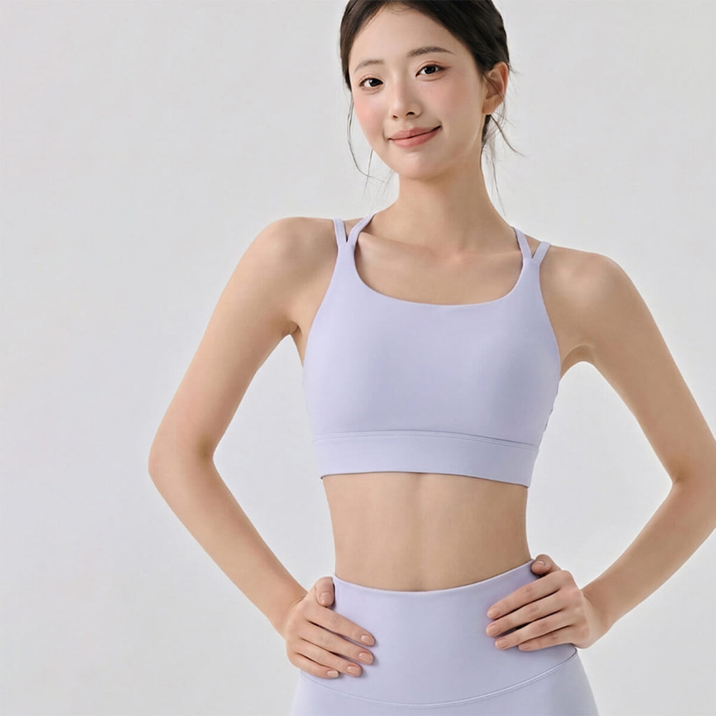 Woman in purple yoga set with hands on hips.