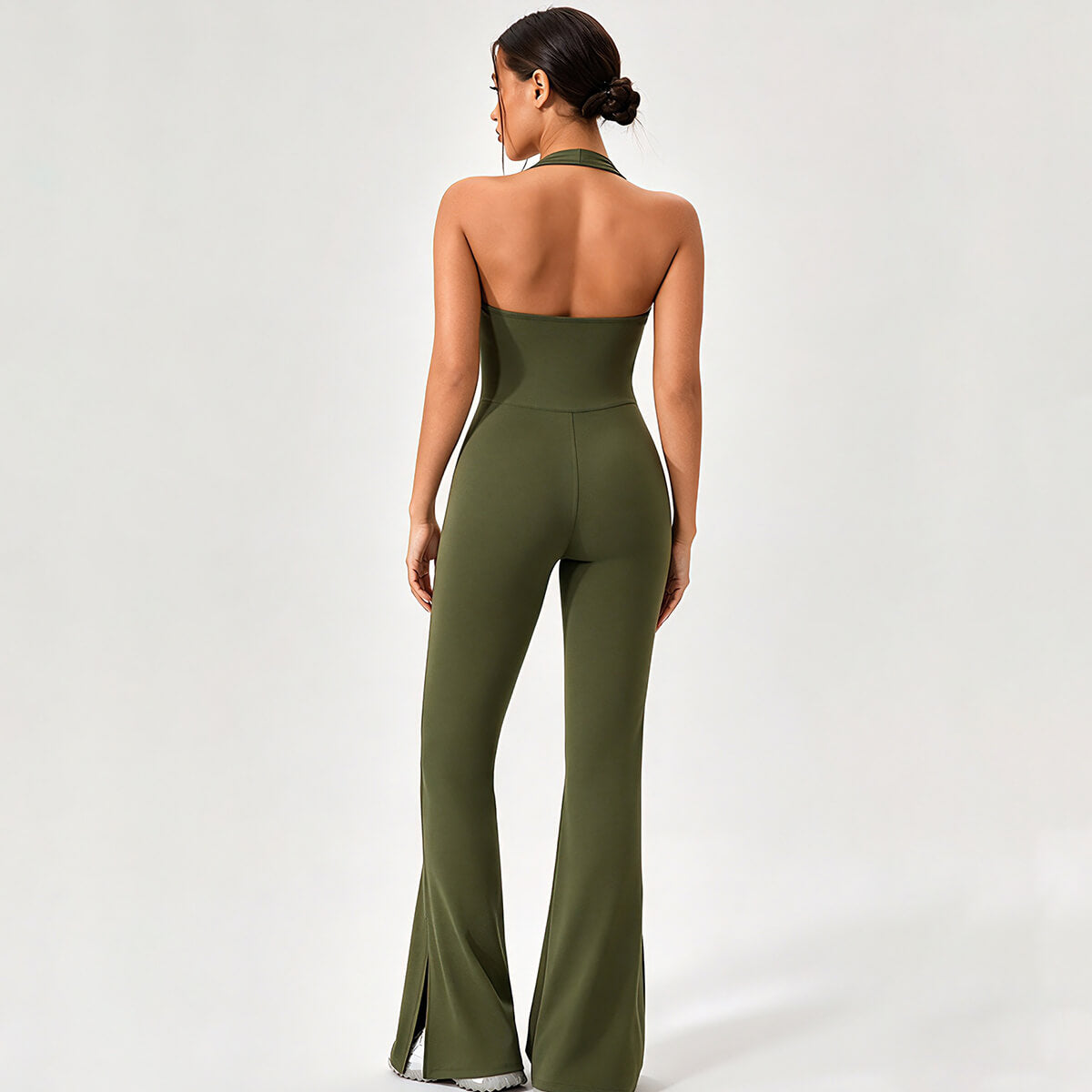 Back view of an olive green halter open-back flare athletic jumpsuit.