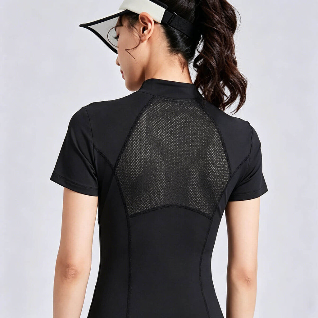 Back view of a women's black half-zip athletic top featuring a large breathable mesh panel for maximum ventilation during tennis, golf, or gym workouts.